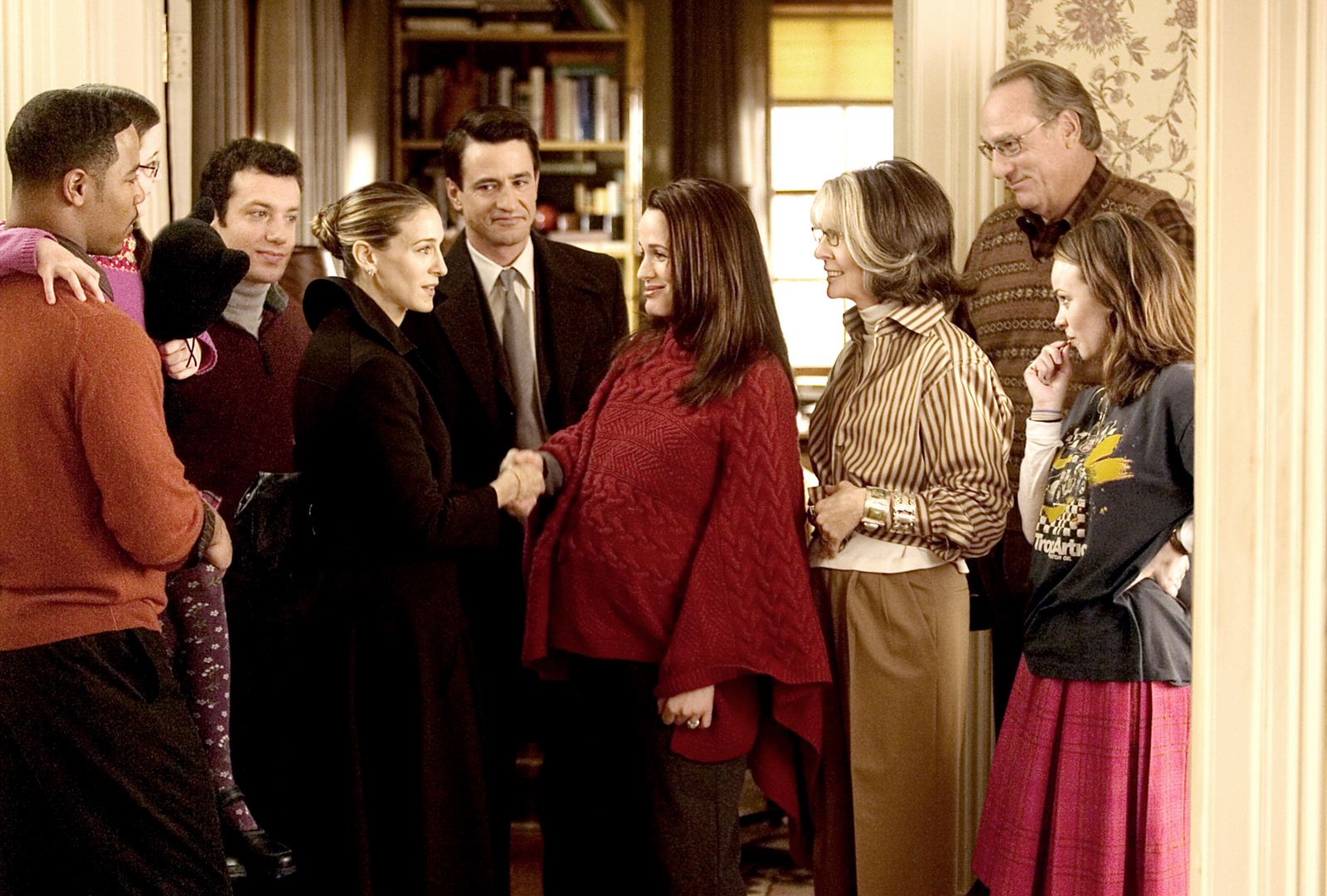 Fotograma de la película de 2005: la familia Stone al completo en el recibidor de la casa mientras Sarah Jessica Parker estrecha la mano de una de las hijas; Diane Keaton, con camisa de rayas y gafas, observa a la derecha